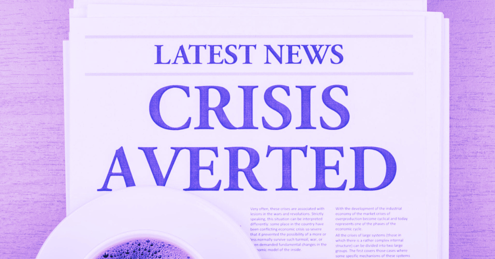 A newspaper which reads 'Crisis averted' with a cup of coffee and a purple filter applied